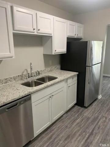 a kitchen with a sink a refrigerator and cabinets