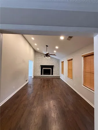a view of empty room with wooden floor and fireplace