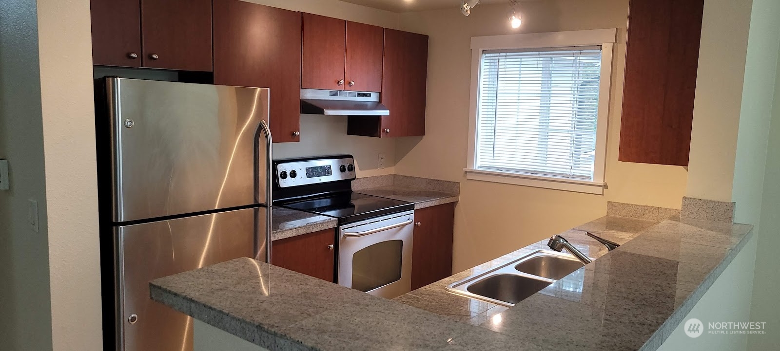 12404 East Gibson Road, Unit D201 Everett, WA 98204 - Photo 5 of 22 a kitchen with stainless steel appliances granite countertop a refrigerator a sink a stove a microwave and island
