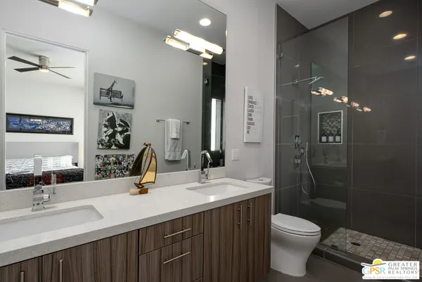a bathroom with a double vanity sink toilet and shower