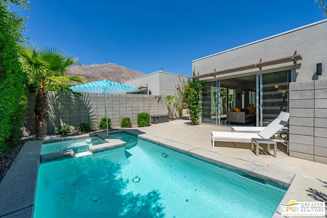 a view of a house with swimming pool and sitting area