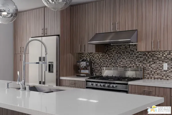 a kitchen with granite countertop a stove and a refrigerator