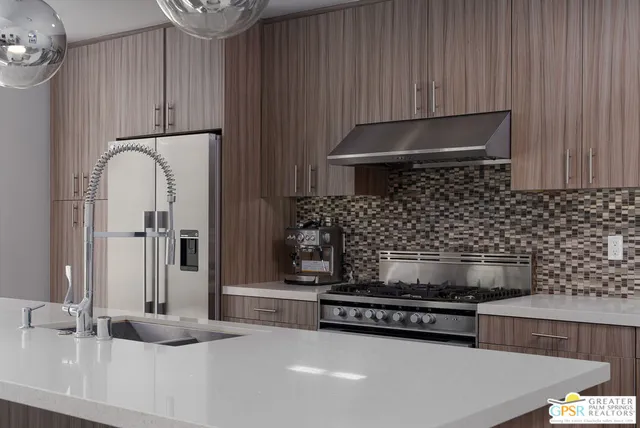 a kitchen with granite countertop a stove and a refrigerator