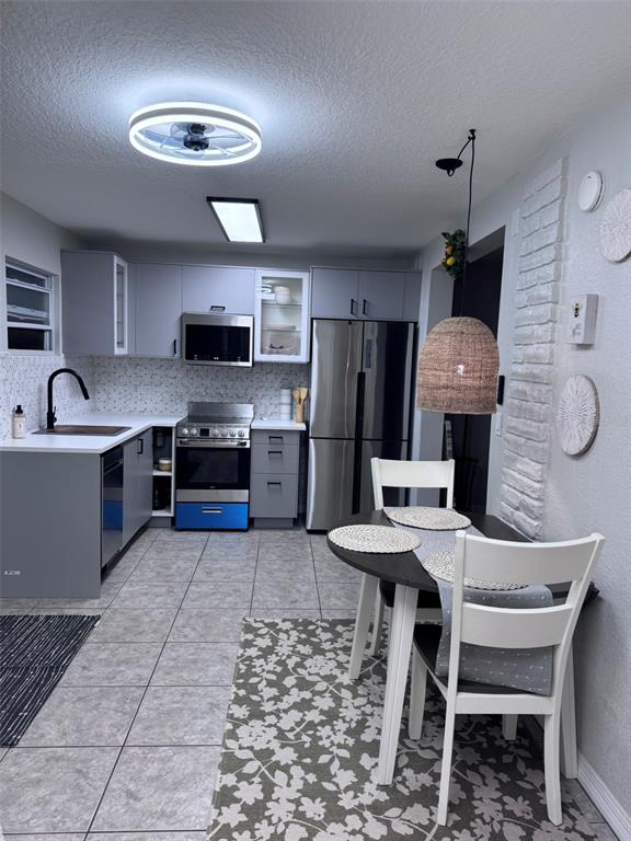 6304 Beechwood Avenue Sarasota, FL 34231 - Photo 13 of 41 a kitchen with stainless steel appliances granite countertop a sink a stove a microwave a dining table and chairs