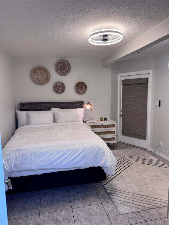 6304 Beechwood Avenue Sarasota, FL 34231 - Photo 9 of 41 a bedroom with a large bed and a chandelier