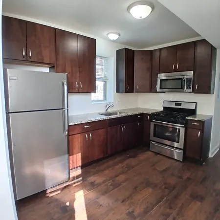 a kitchen with granite countertop stainless steel appliances and refrigerator