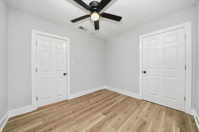 a view of empty room with wooden floor