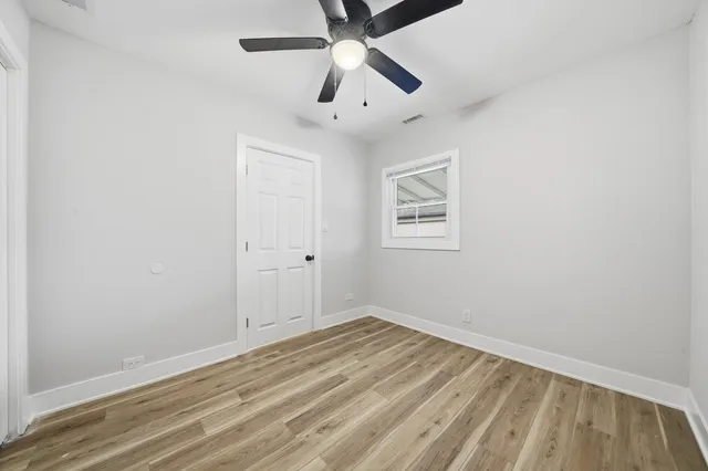 an empty room with a window and a ceiling fan