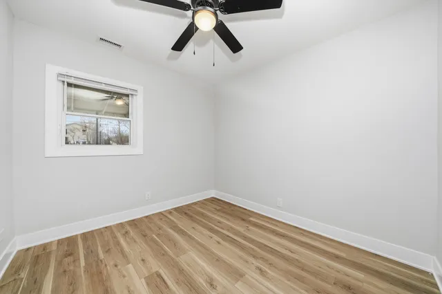 a view of a room with wooden floor and white walls