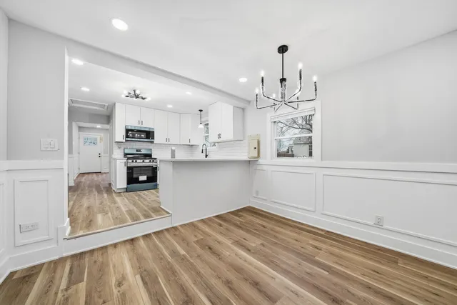a kitchen with kitchen island white cabinets and stainless steel appliances