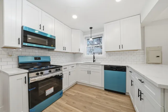 a kitchen with stainless steel appliances white cabinets granite counter tops and a stove top oven