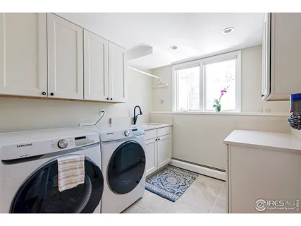 a utility room with cabinets washer and dryer