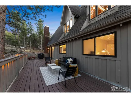 a balcony with wooden floor and outdoor seating