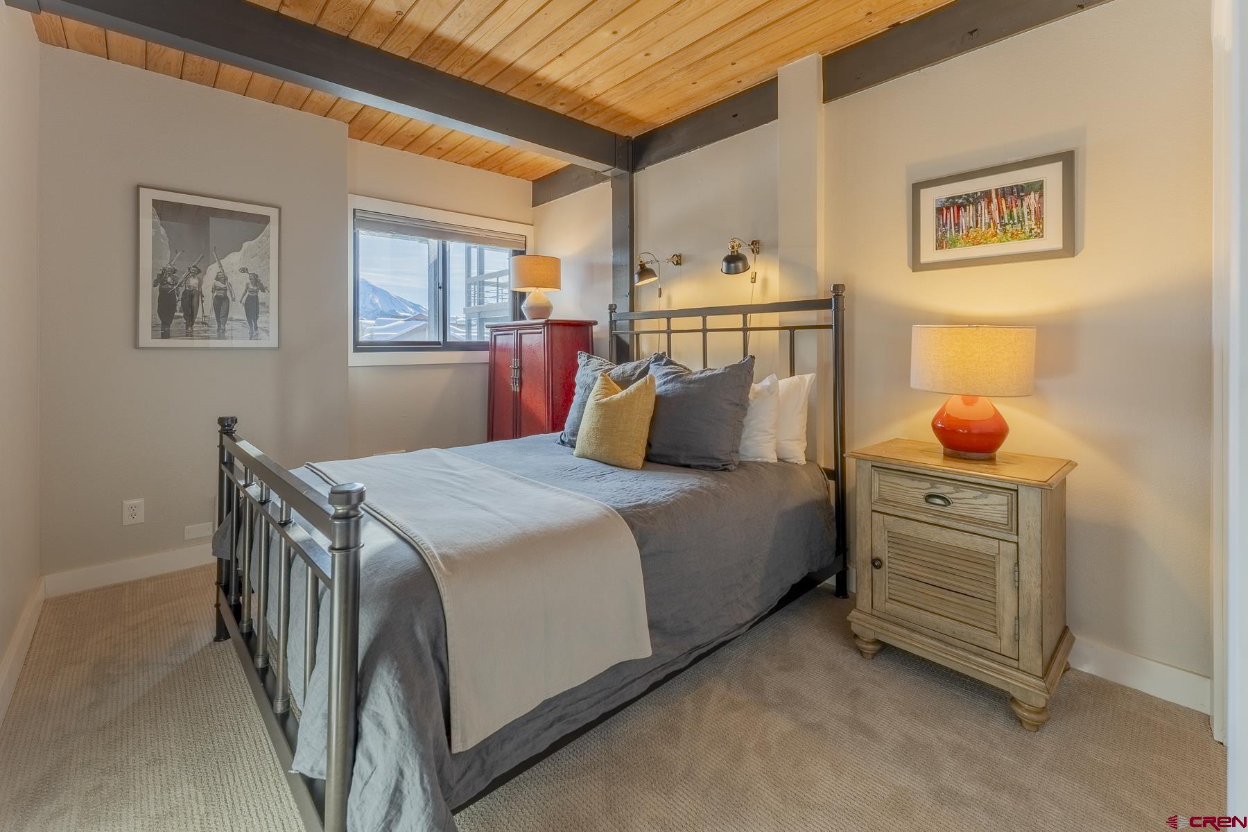 400 Gothic Road, Unit 207 Crested Butte, CO 81225 - Photo 20 of 35 a bedroom with a bed and wooden floor