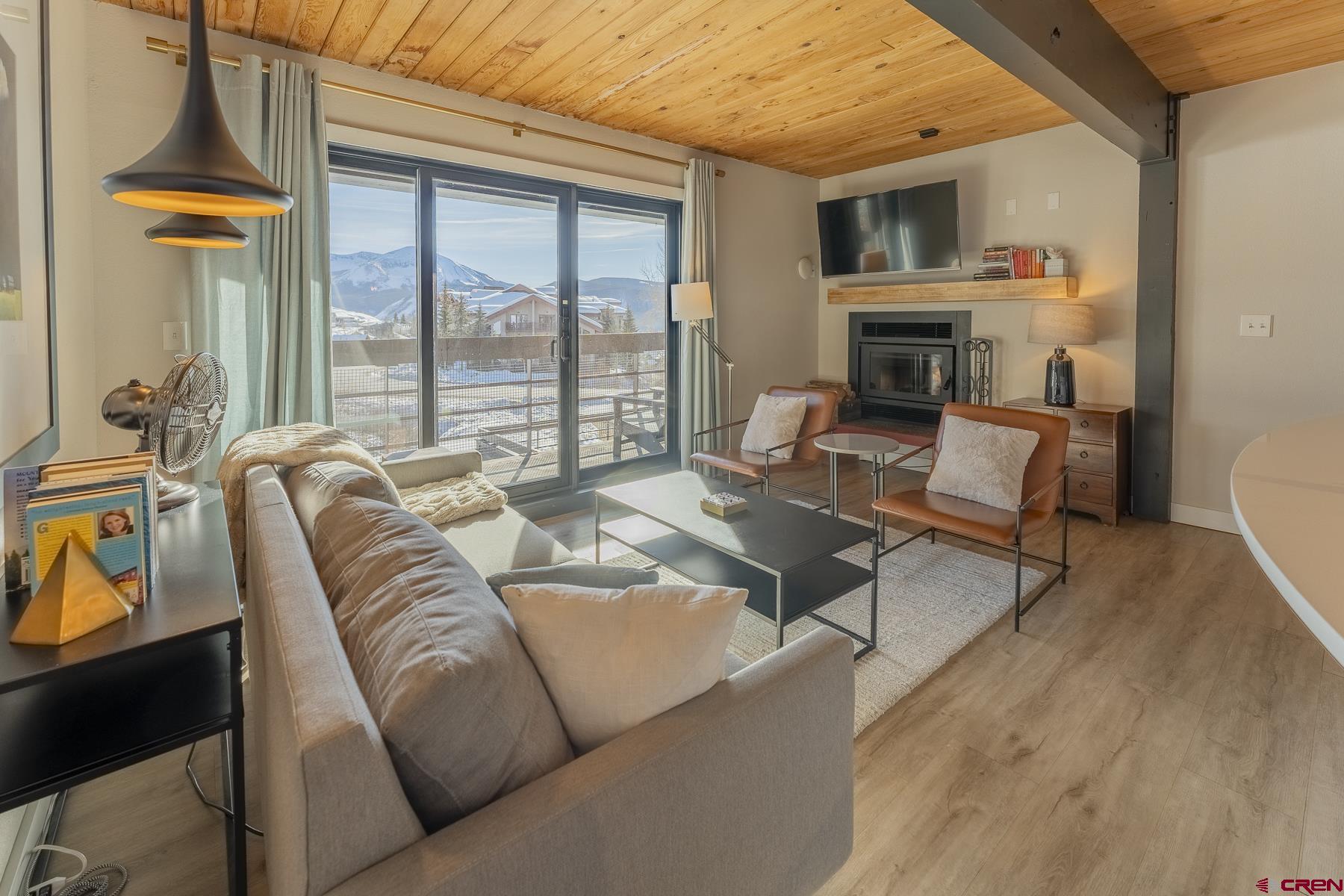 400 Gothic Road, Unit 207 Crested Butte, CO 81225 - Photo 2 of 35 a living room with furniture fireplace and a table