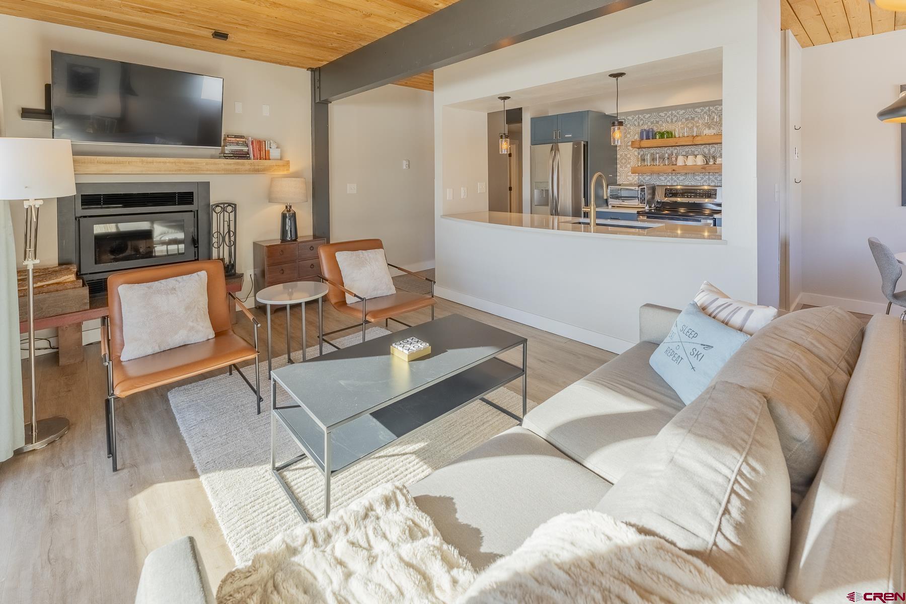 400 Gothic Road, Unit 207 Crested Butte, CO 81225 - Photo 7 of 35 a living room with furniture a flat screen tv and a fireplace
