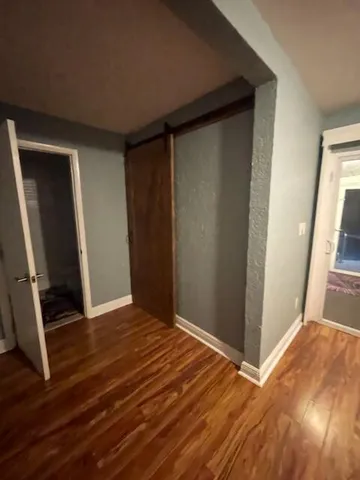 a view of empty room with wooden floor