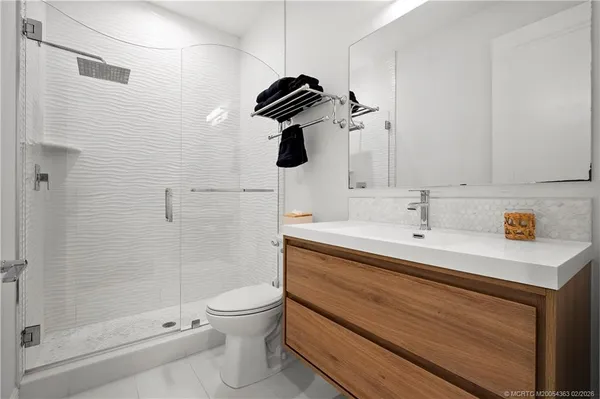 a bathroom with a granite countertop sink a toilet and shower