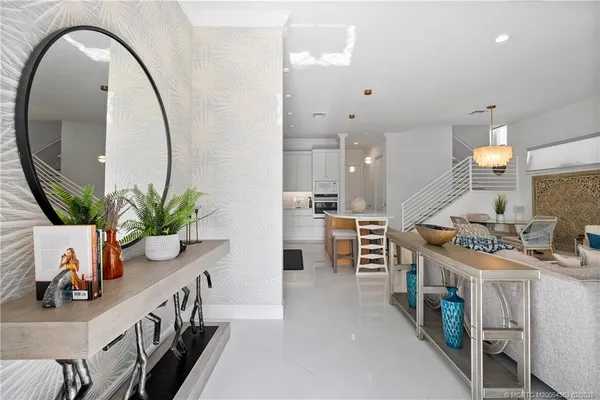 a kitchen with stainless steel appliances a table chairs in it and wooden floors