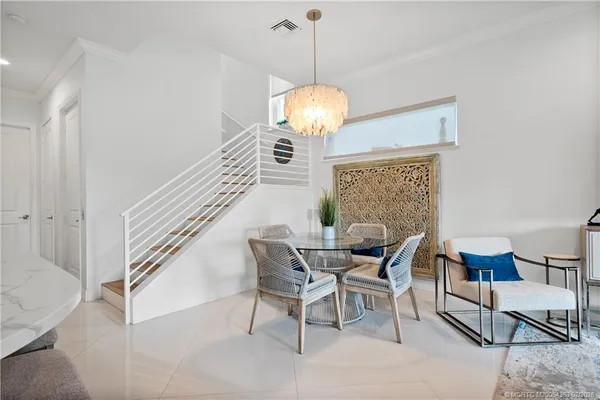 a dining room with furniture a chandelier and window