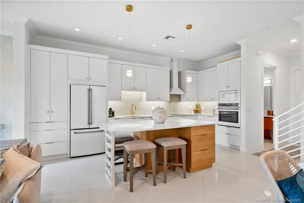 a kitchen with refrigerator and chairs