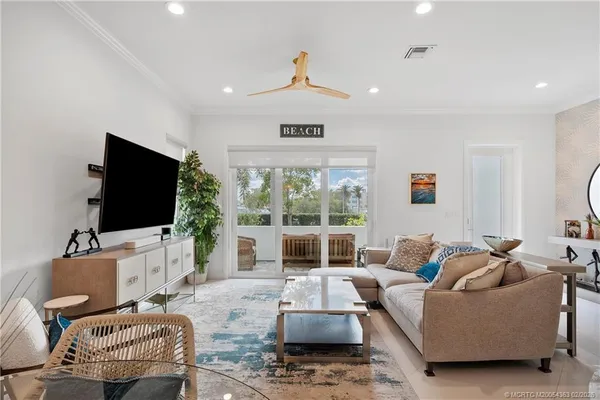 a living room with furniture a flat screen tv and a large window