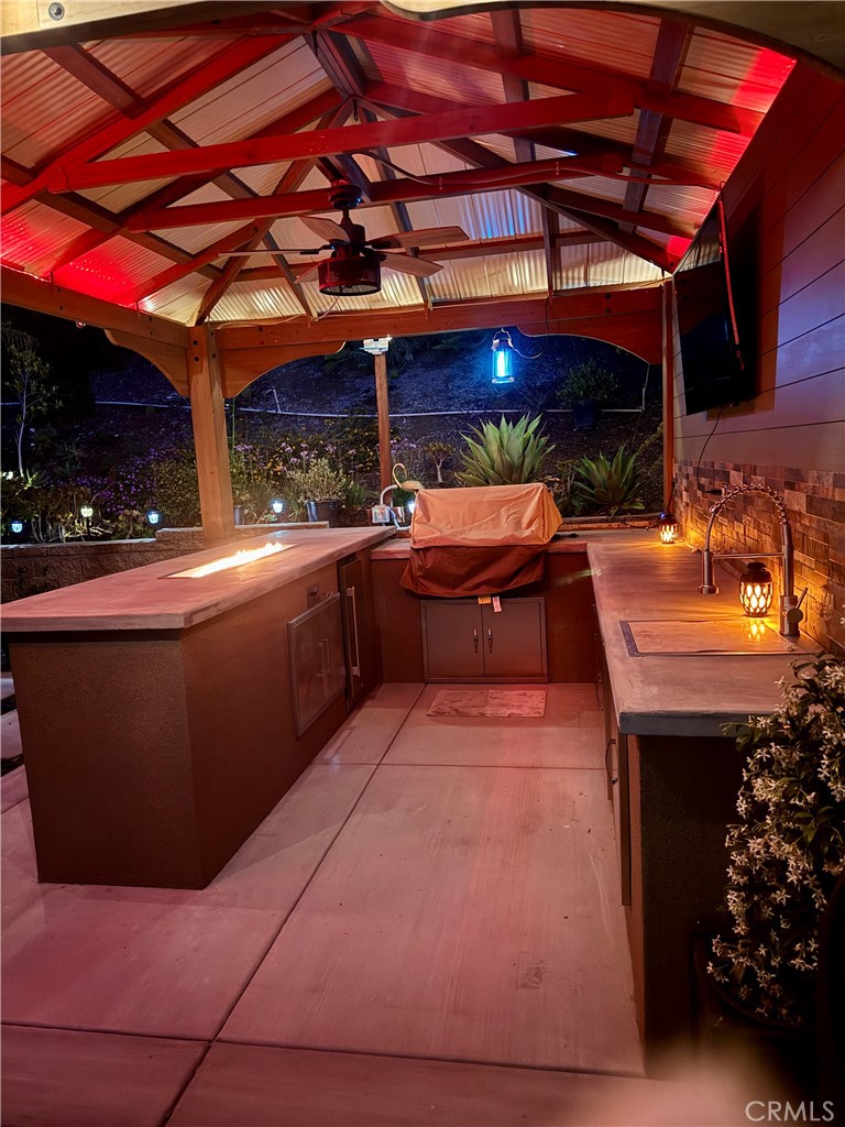 11137 Briar Rose Court Corona, CA 92883 - Photo 44 of 75 a view of a patio with table and chairs with wooden floor and a fireplace