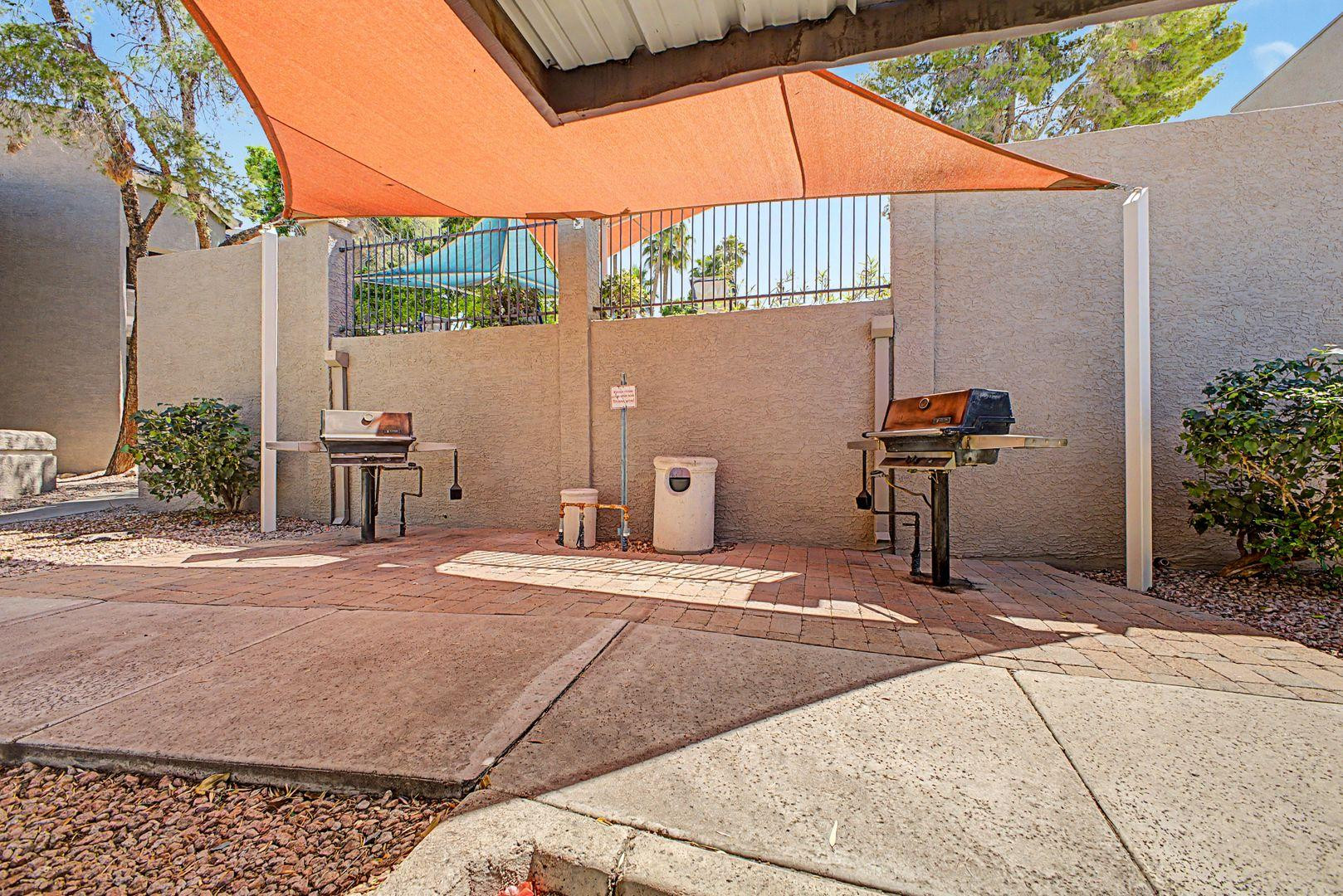 1720 East Thunderbird Road, Unit 1086 Phoenix, AZ 85022 - Photo 21 of 32 a backyard of a house with table and chairs under an umbrella