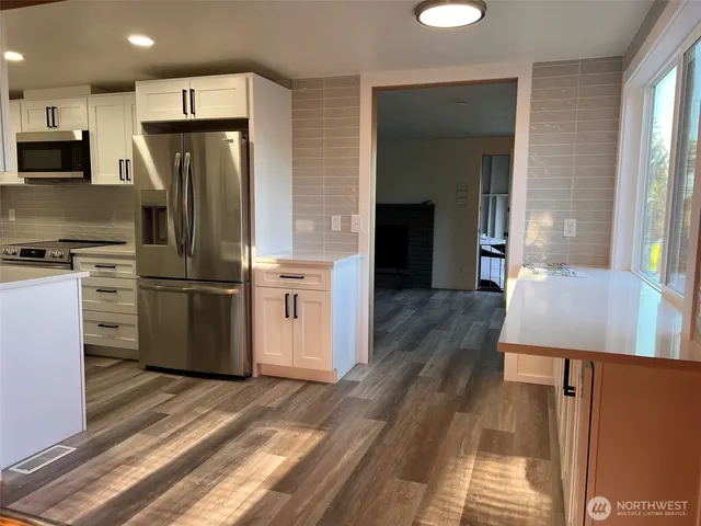 a kitchen with stainless steel appliances a refrigerator and a stove top oven