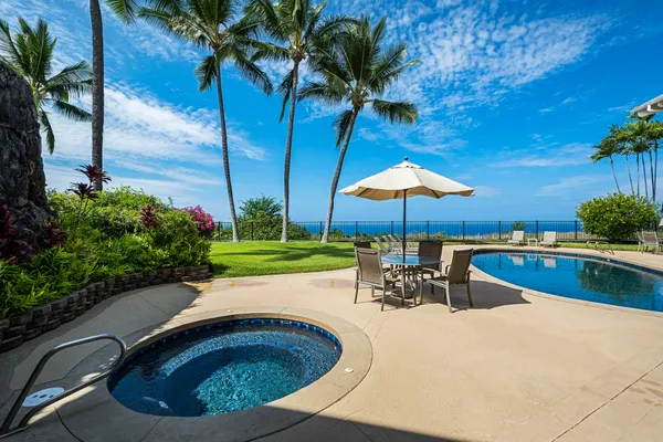 a view of a swimming pool with a table and chairs under an umbrella