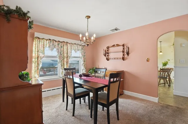 a dining room with furniture a chandelier and a rug