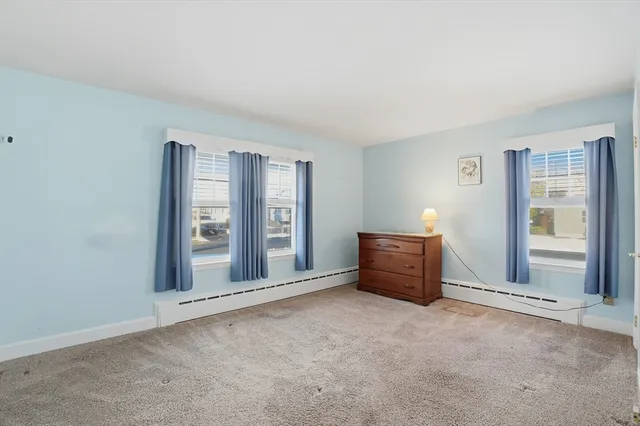 an empty room with windows and cabinet