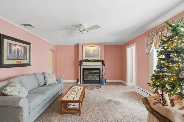 a living room with furniture a fireplace with a large window