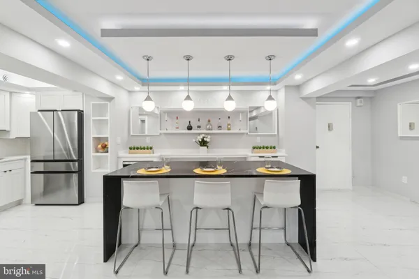 a kitchen with stainless steel appliances a table chairs refrigerator and microwave