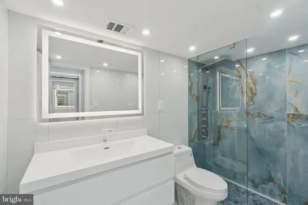 a bathroom with a sink a toilet and shower