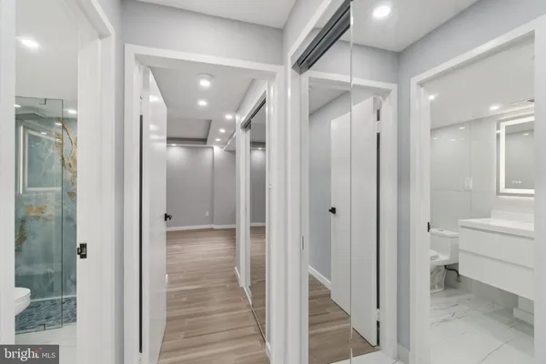 a bathroom with a glass shower door a sink and a mirror