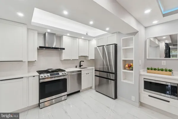 a kitchen with stainless steel appliances a stove a refrigerator and a refrigerator