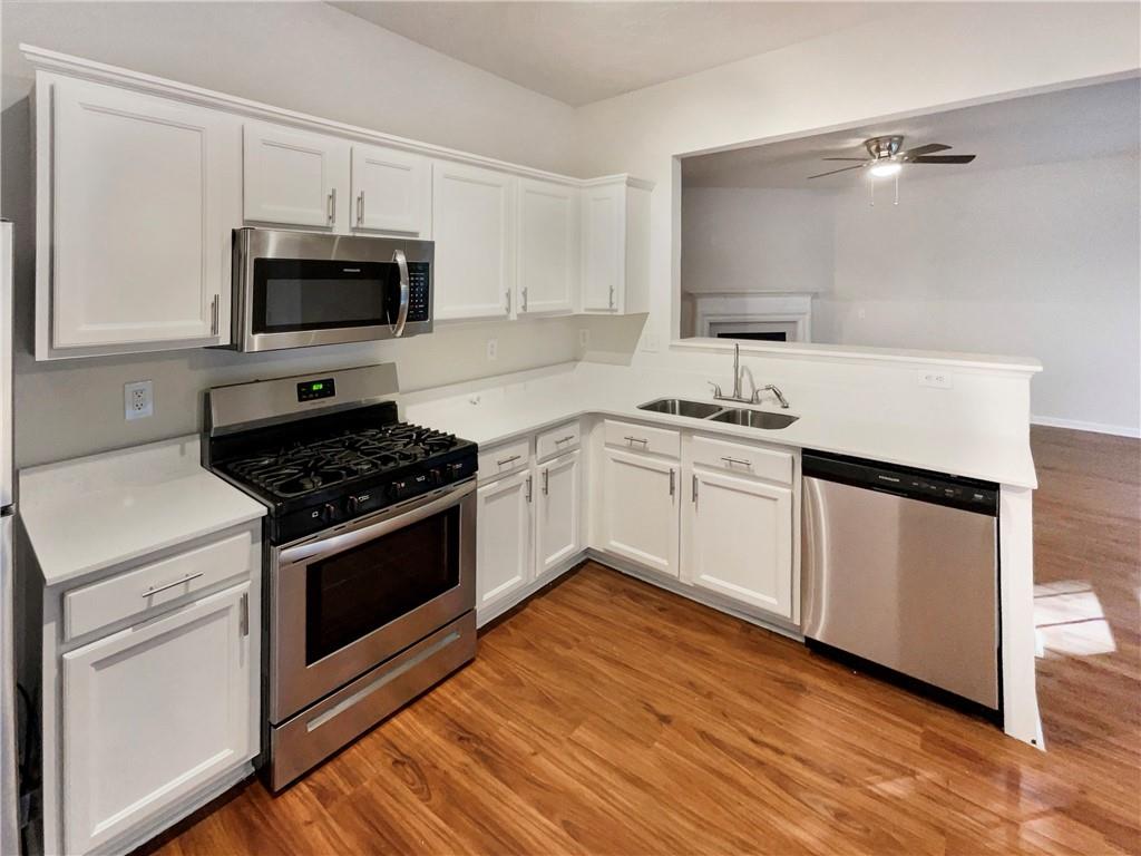11569 Kades Trail Hampton, GA 30228 - Photo 6 of 25 a kitchen with white cabinets and appliances