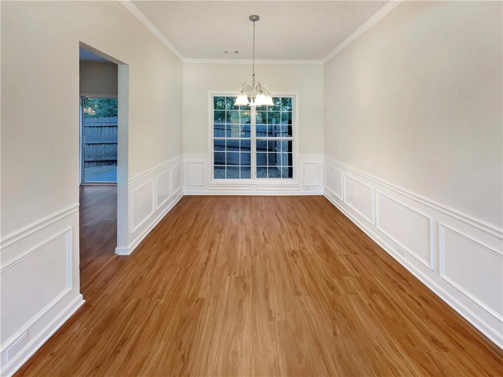 11569 Kades Trail Hampton, GA 30228 - Photo 9 of 25 a view of an empty room with wooden floor and a window