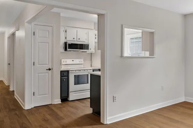 a view of kitchen with stainless steel appliances cabinets and wooden floor