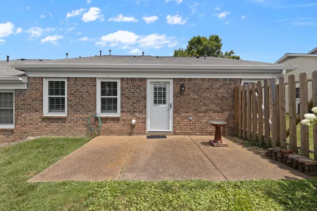 a backyard of a house with table and chairs