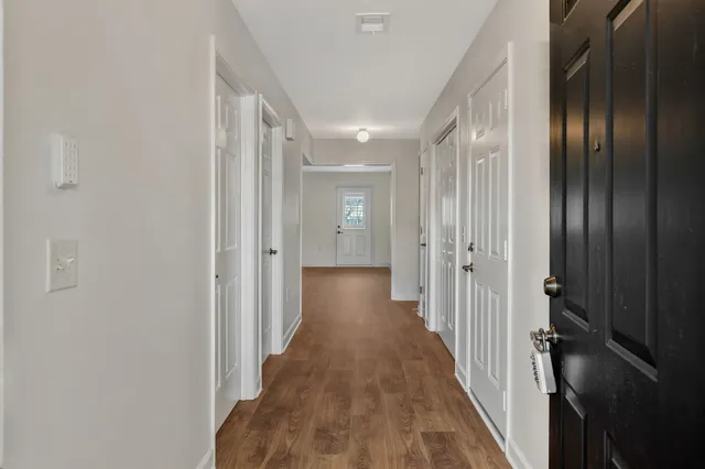 a view of a hallway with wooden floor
