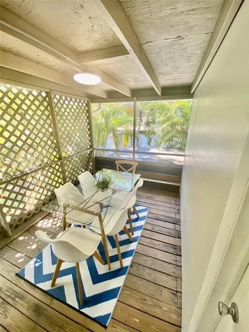 a view of a balcony with chairs and wooden floor