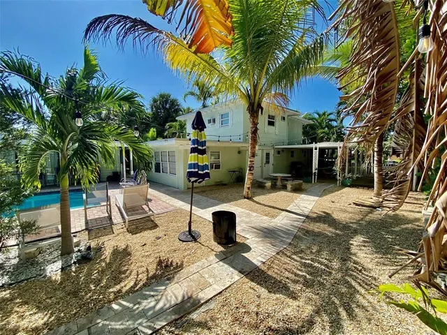 a view of backyard with swimming pool and furniture
