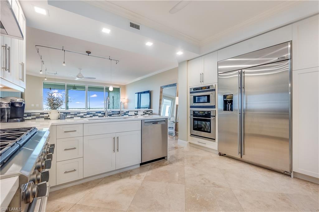275 Indies Way, Unit 1002 Naples, FL 34110 - Photo 18 of 48 Kitchen featuring decorative backsplash, high quality appliances