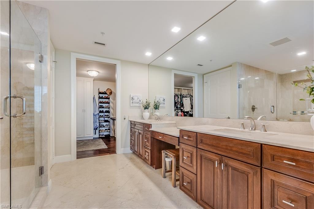275 Indies Way, Unit 1002 Naples, FL 34110 - Photo 21 of 48 Primary bathroom, a spacious closet, a shower stall, and vanity
