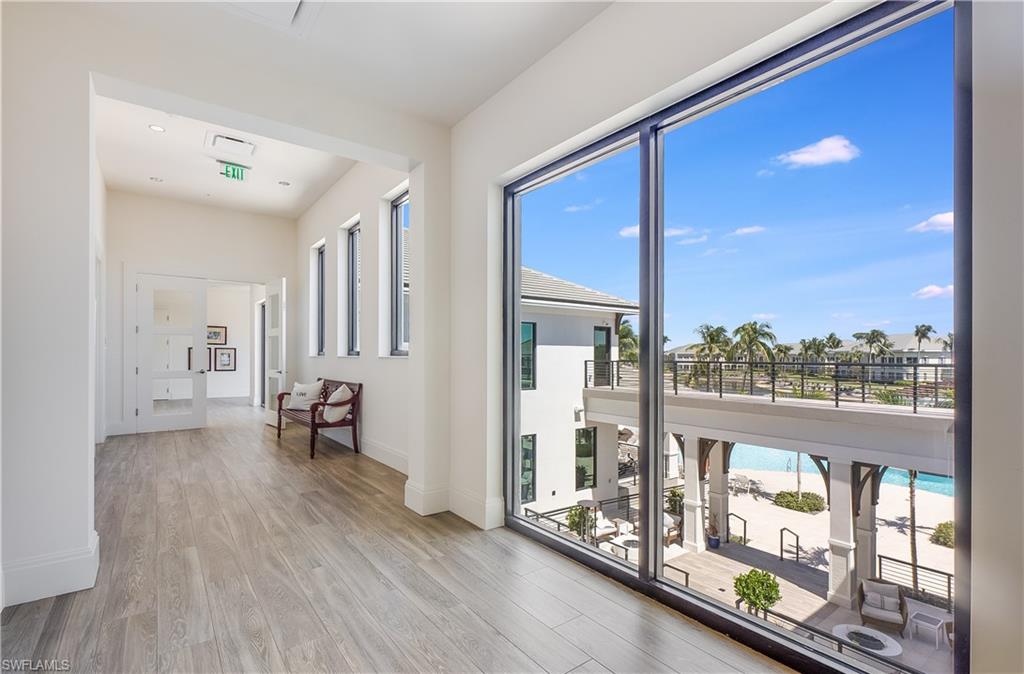 275 Indies Way, Unit 1002 Naples, FL 34110 - Photo 37 of 48 Doorway to outside featuring baseboards and wood finished floors