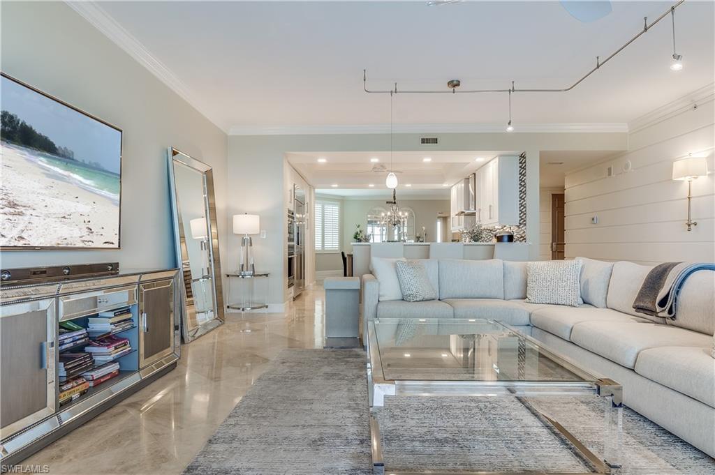 275 Indies Way, Unit 1002 Naples, FL 34110 - Photo 10 of 48 Living room featuring marble finish floor, a chandelier, and crown molding