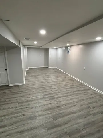 an empty room with wooden floor and windows in a room