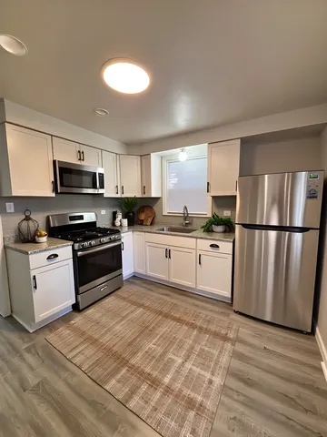 a kitchen with granite countertop a refrigerator stove top oven and sink